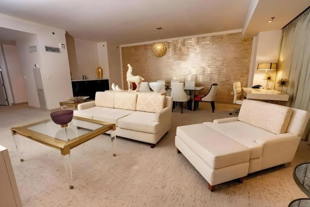 a living room with two white couches and a table at Ahern Hotel and Event Center in Las Vegas