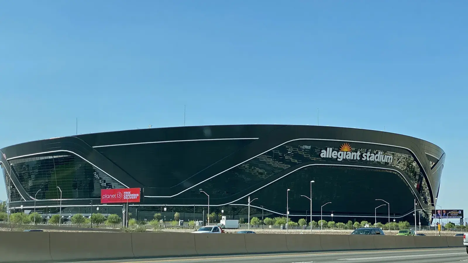 Allegiant Stadium's black glass exterior seen from the freeway
