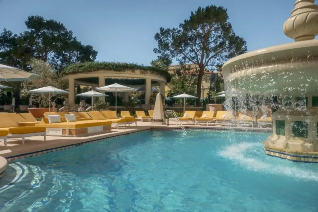 a pool with chairs and a fountain in a hotel at Bellagio in Las Vegas