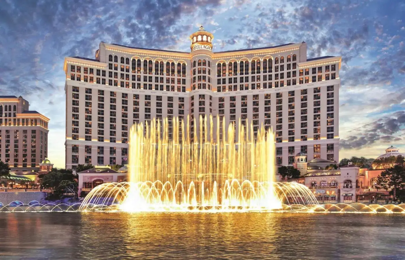 a fountain in the water in front of a large building at Bellagio in Las Vegas