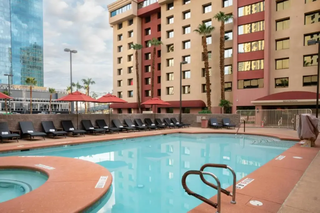 a swimming pool in a hotel with chairs and buildings at The Carriage House in Las Vegas