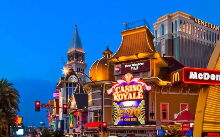 a city street with many shops and buildings at night at Best Western Plus Casino Royale–Center Strip in Las Vegas