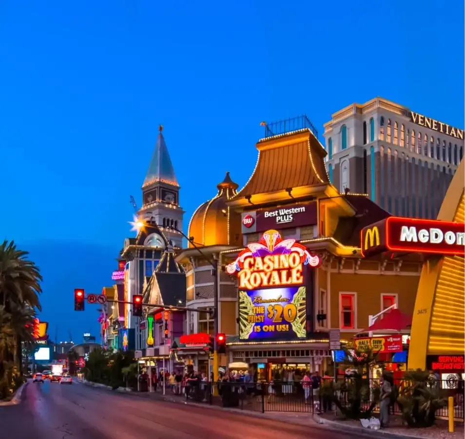 a city street with many shops and buildings at night at Best Western Plus Casino Royale–Center Strip in Las Vegas