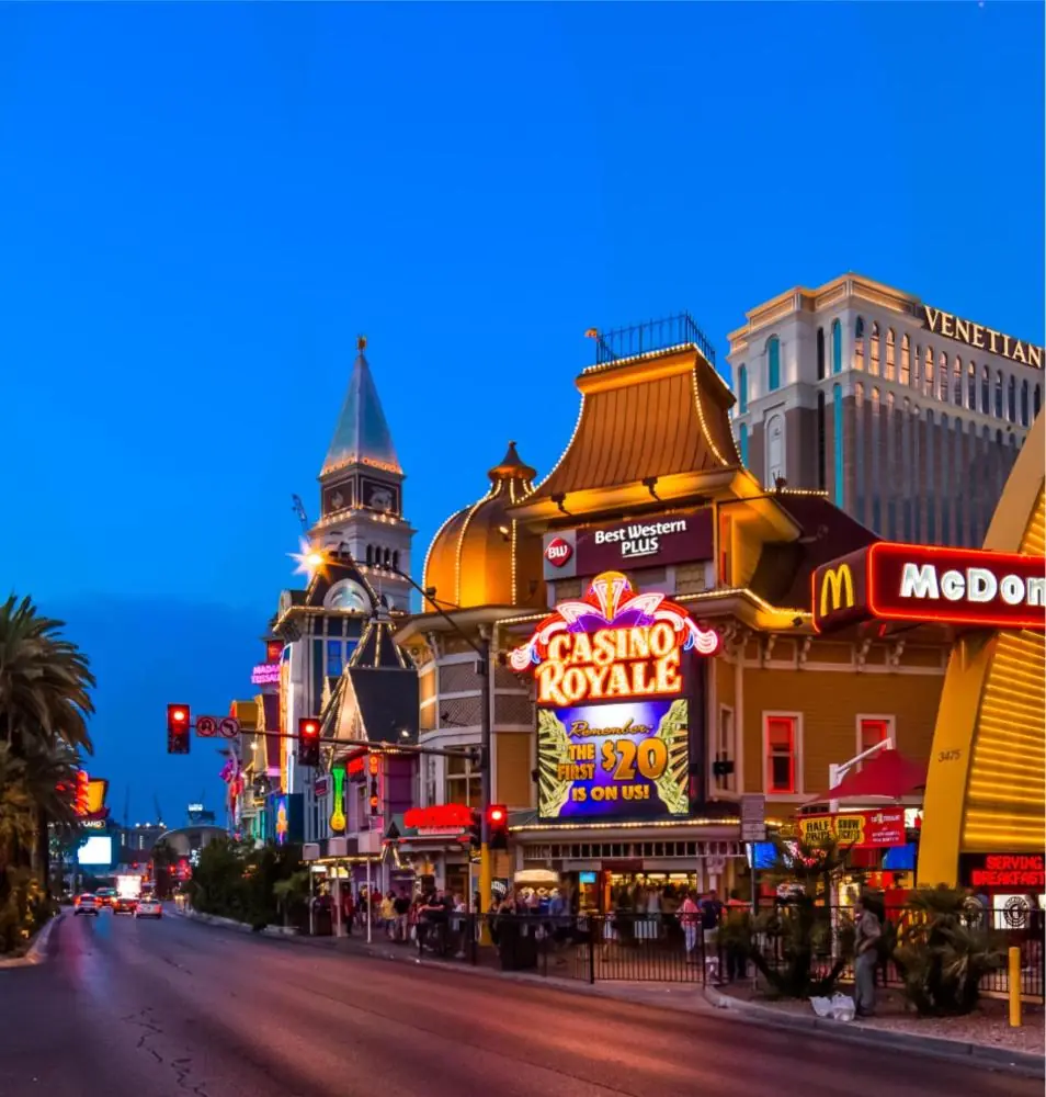 a city street with many shops and buildings at night at Best Western Plus Casino Royale–Center Strip in Las Vegas