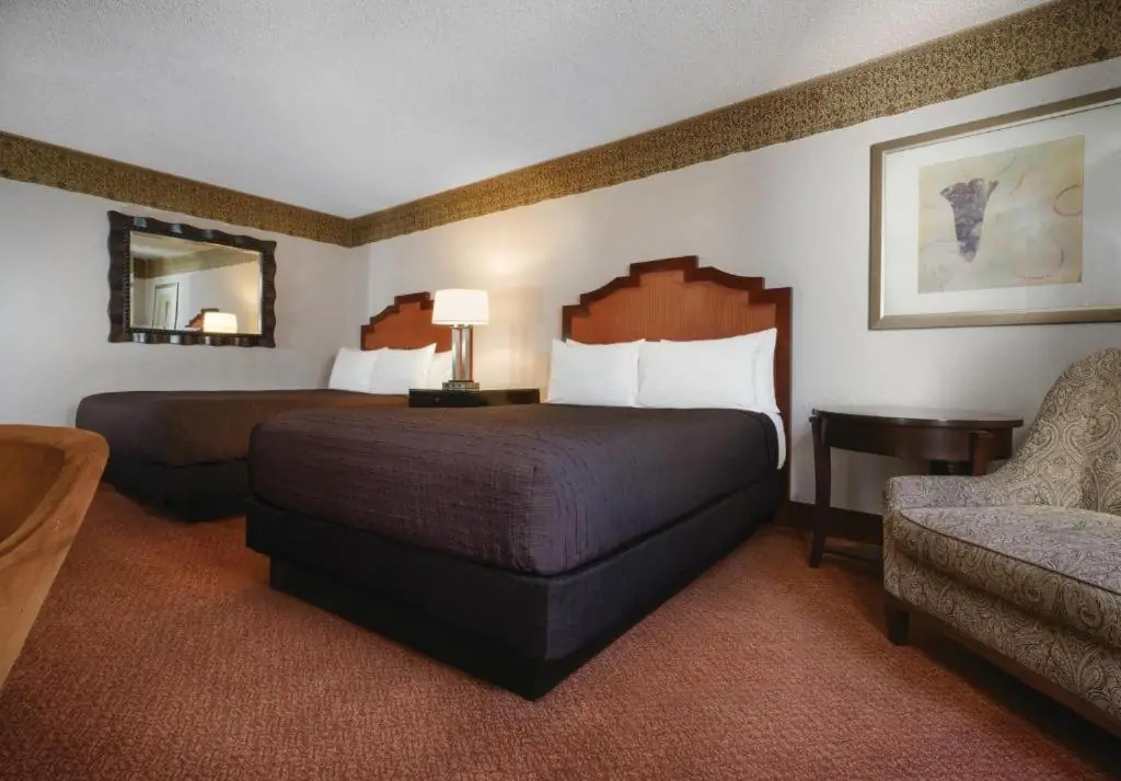 a hotel room with two beds and a chair at Circus Circus Hotel, Casino & Theme Park in Las Vegas
