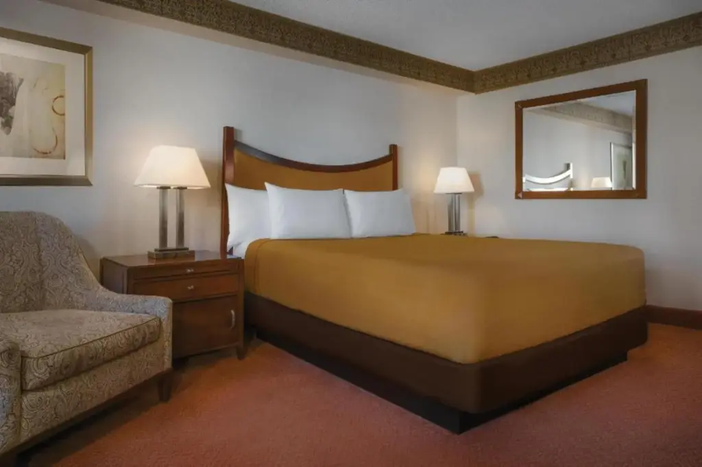 a hotel room with a large bed and a chair at Circus Circus Hotel, Casino & Theme Park in Las Vegas