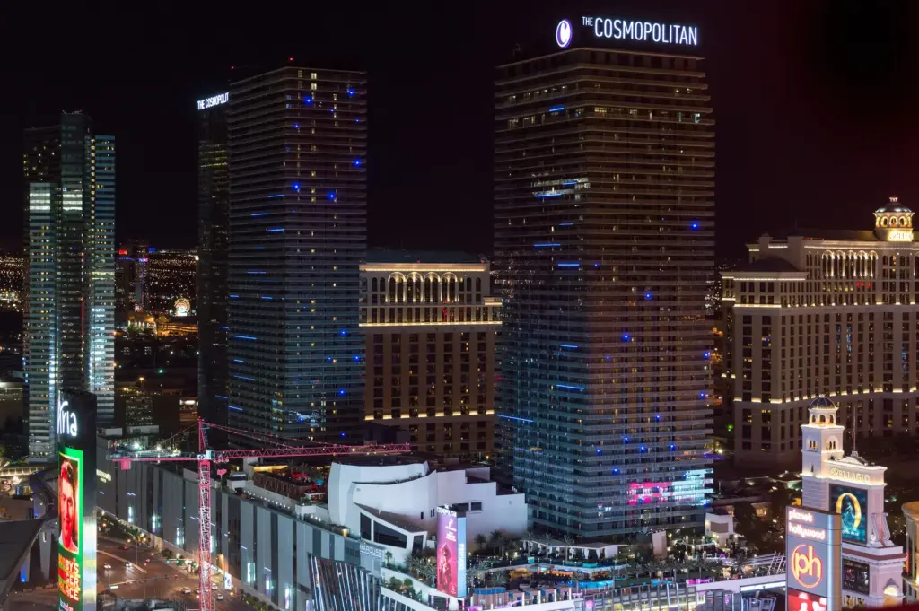 The Cosmopolitan of Las Vegas towers lit up in the evening next to Bellagio