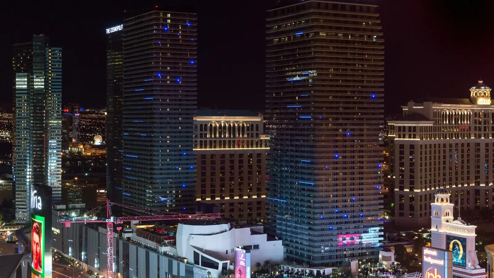 The Cosmopolitan of Las Vegas towers lit up in the evening next to Bellagio