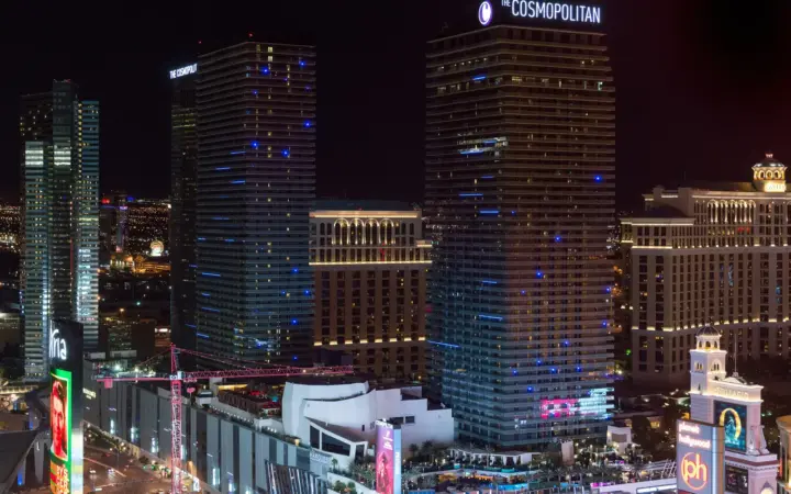 The Cosmopolitan of Las Vegas towers lit up in the evening next to Bellagio