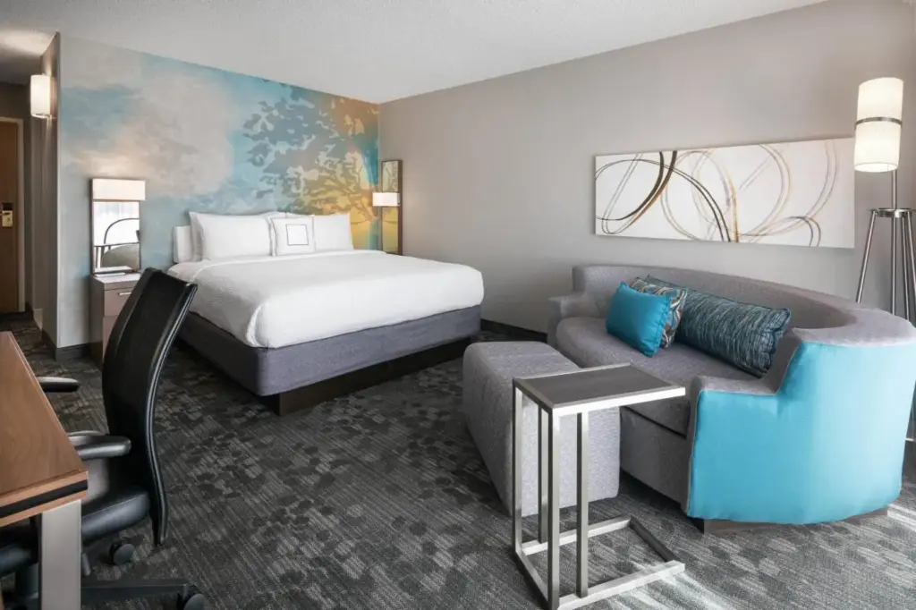 a hotel room with a bed and a couch at Courtyard by Marriott Las Vegas Convention Center in Las Vegas