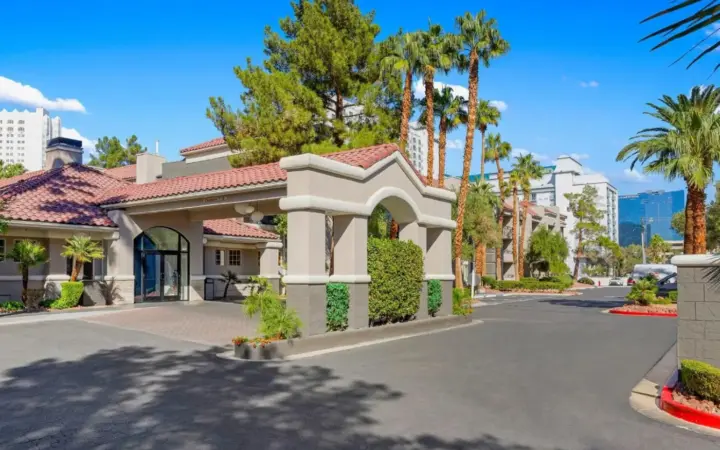 a house with palm trees on a street at Desert Rose Resort in Las Vegas