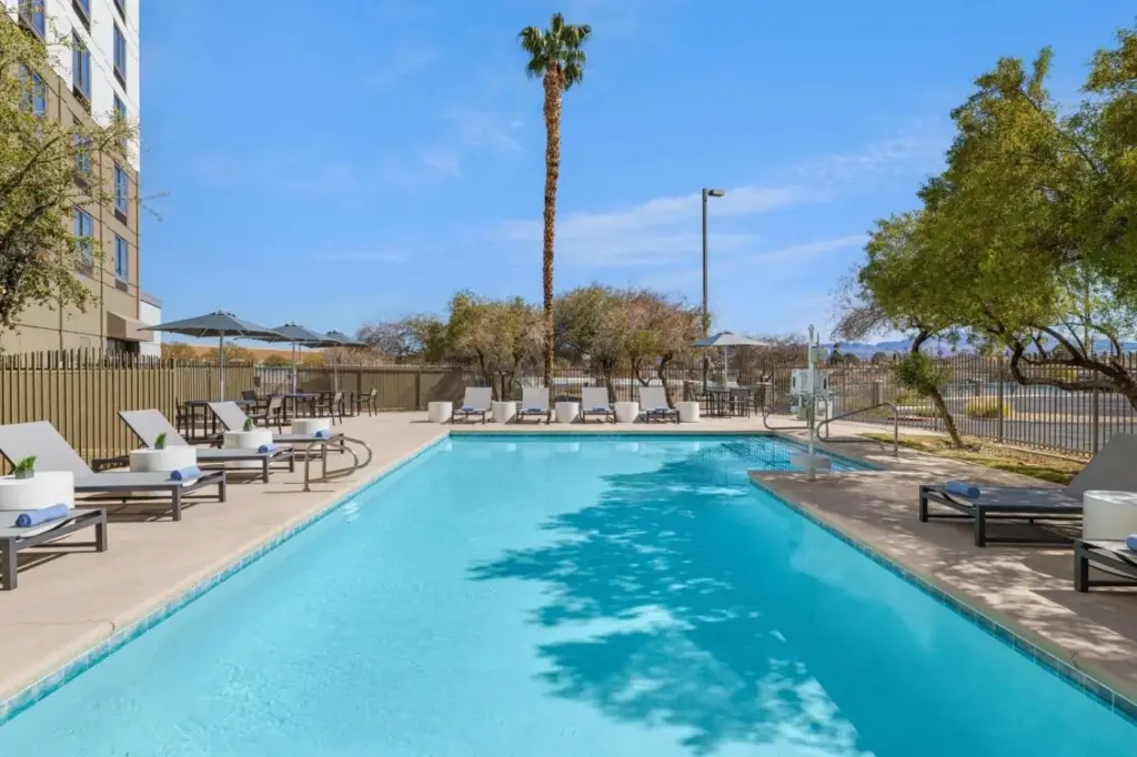 a swimming pool with lounge chairs and a palm tree at DoubleTree by Hilton Las Vegas Airport in Las Vegas