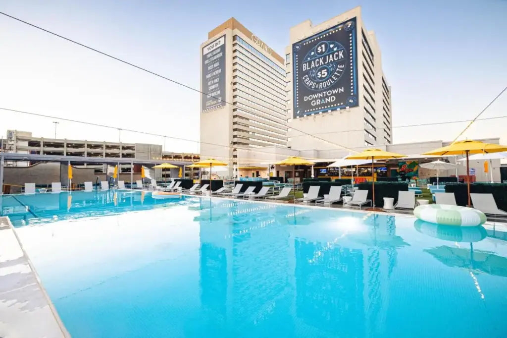a large pool with chairs and umbrellas in front of a hotel at Downtown Grand Hotel & Casino in Las Vegas