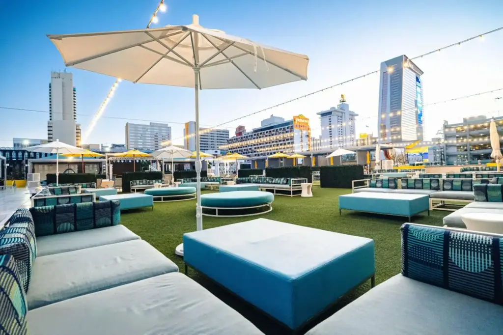 a rooftop patio with blue and white furniture and an umbrella at Downtown Grand Hotel & Casino in Las Vegas