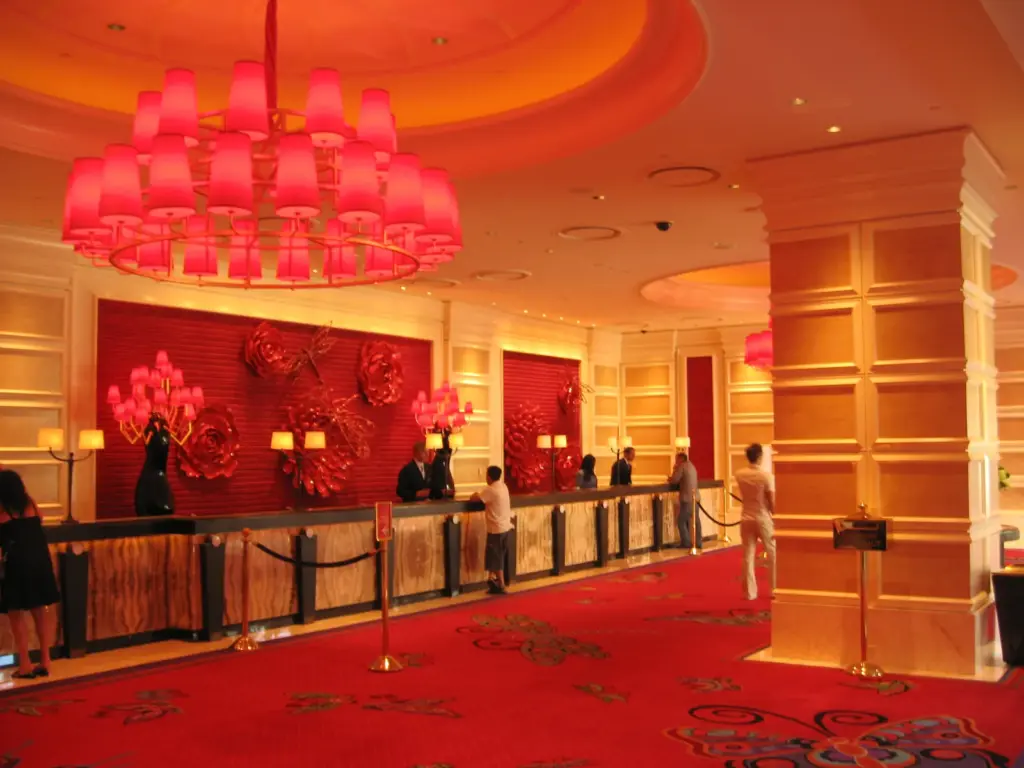 Front desk under red chandeliers in the hotel lobby at Encore Las Vegas