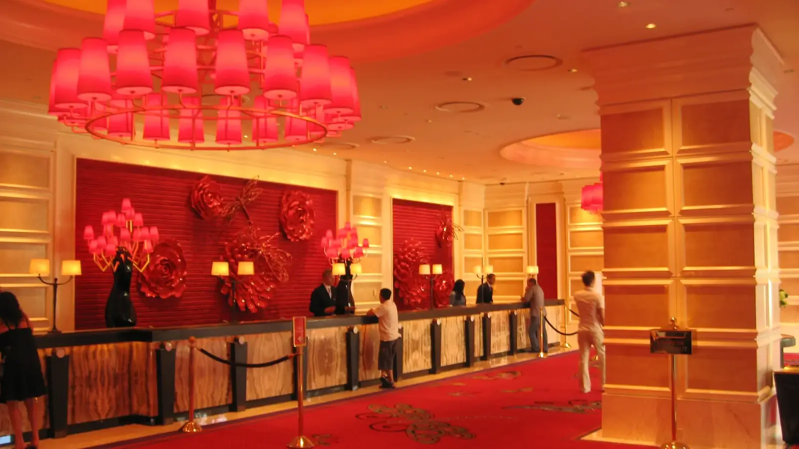 Front desk under red chandeliers in the hotel lobby at Encore Las Vegas