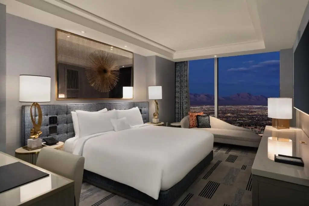 a bedroom with a large white bed and a living room at Fontainebleau Las Vegas, MICHELIN Key Award Hotel in Las Vegas