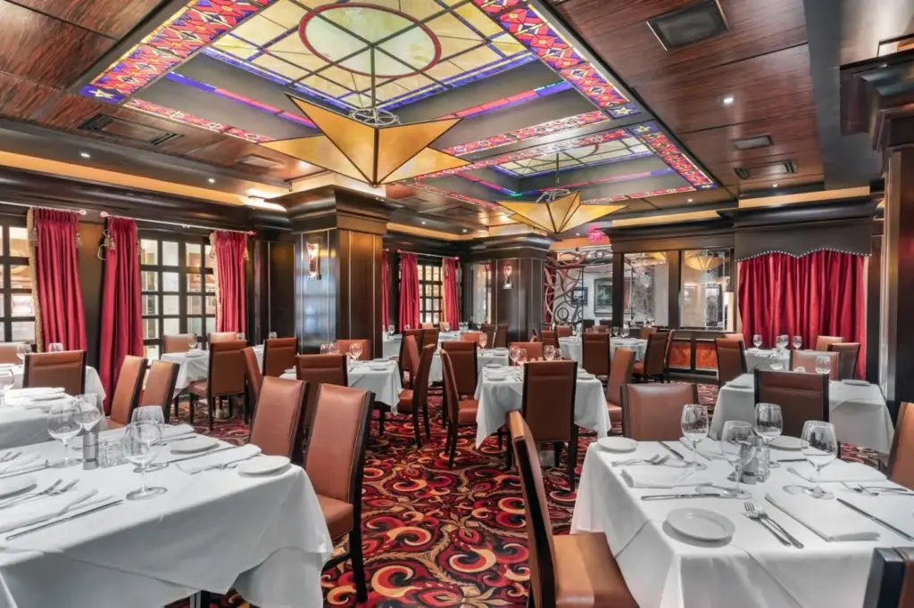 a restaurant with white tables and chairs and a chandelier at Golden Nugget Hotel & Casino Las Vegas in Las Vegas