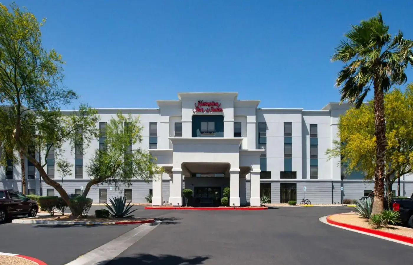 a white building with a parking lot in front of it at Hampton Inn & Suites Las Vegas Airport in Las Vegas