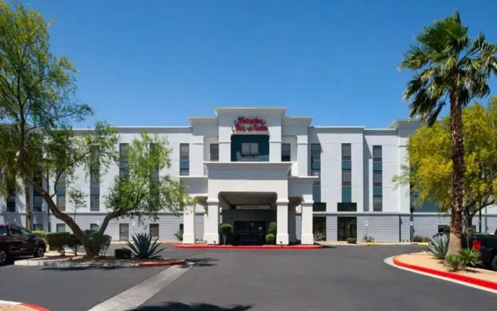 a white building with a parking lot in front of it at Hampton Inn & Suites Las Vegas Airport in Las Vegas