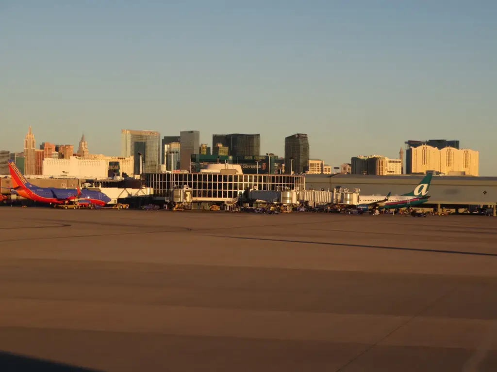 Planes at Harry Reid International Airport with the Las Vegas Strip skyline behind