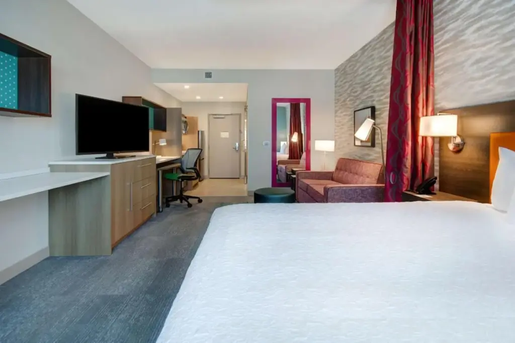 Bed and work area in a Home2 Suites Las Vegas North room