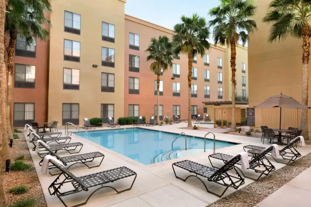 a swimming pool with chairs and a hotel at Homewood Suites by Hilton Las Vegas Airport in Las Vegas