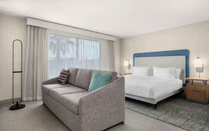 Bed and seating area in a Homewood Suites North Speedway room