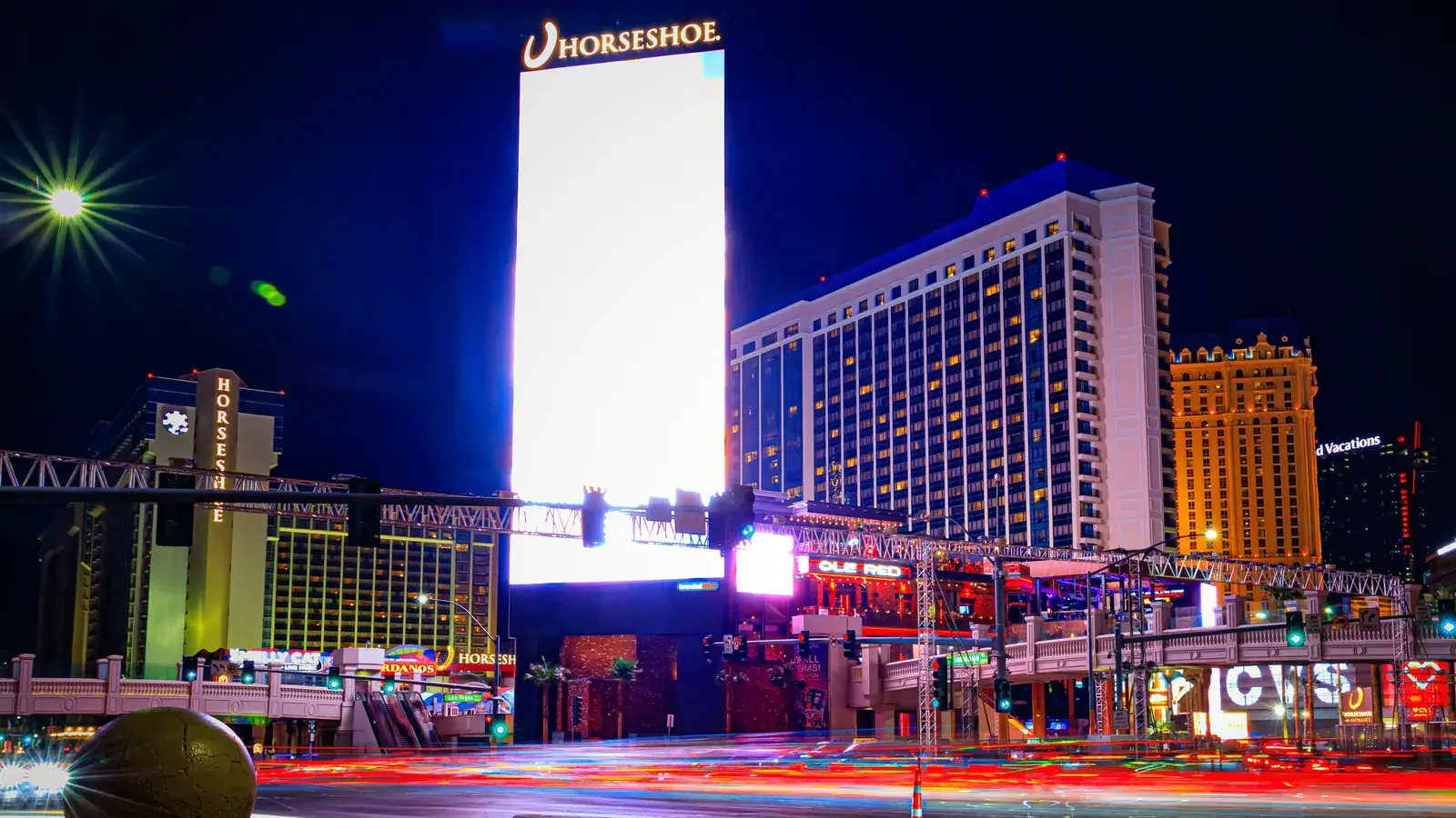 Horseshoe Las Vegas hotel and sign at night with light trails on the Strip