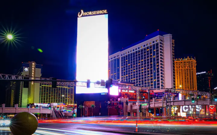 Horseshoe Las Vegas hotel and sign at night with light trails on the Strip