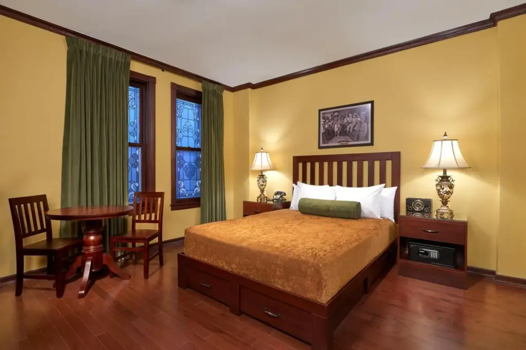 a bedroom with a bed and a table and chairs at Hotel Apache in Las Vegas