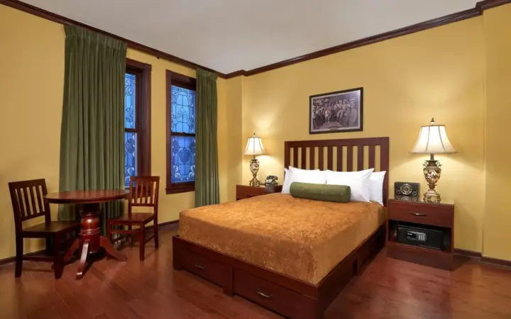 a bedroom with a bed and a table and chairs at Hotel Apache in Las Vegas