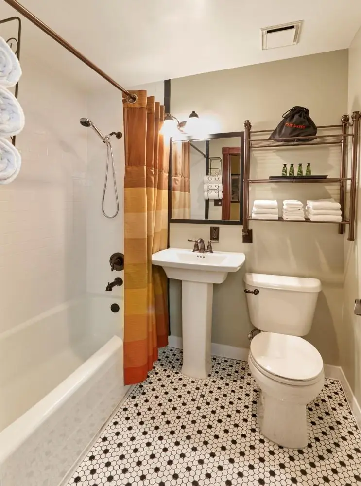a bathroom with a toilet and a sink and a tub at Hotel Apache in Las Vegas