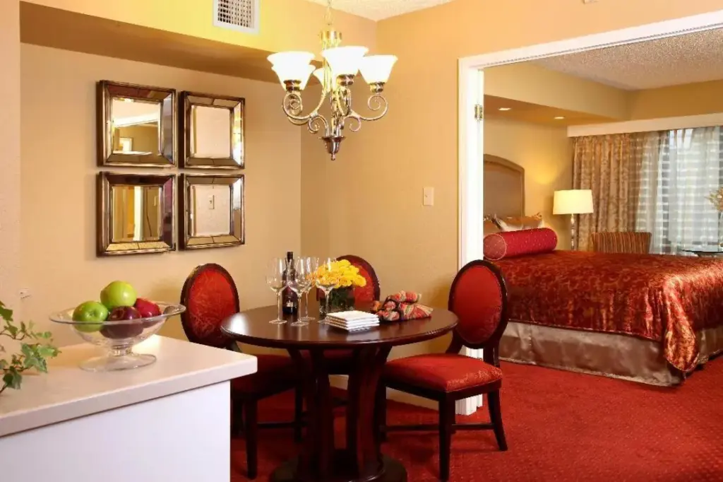 a hotel room with a bed and a table and chairs at Jockey Club Suites in Las Vegas