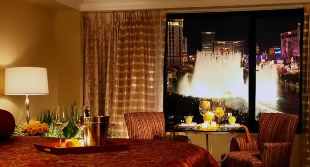 a room with a table and a large window with a fountain at Jockey Club Suites in Las Vegas