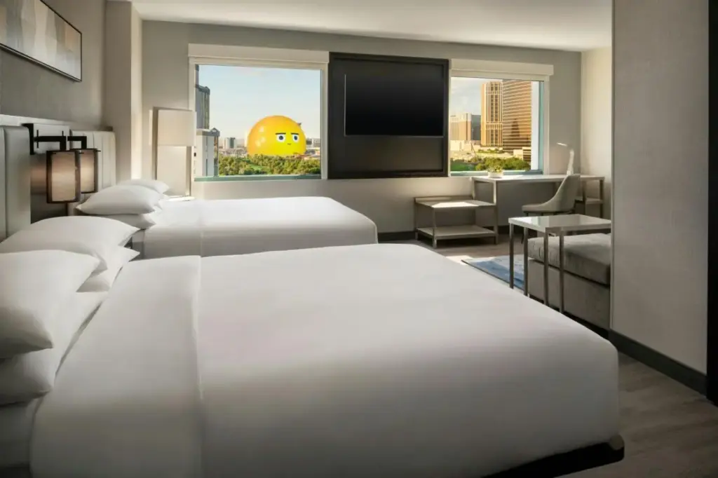 a hotel room with three beds and a flat screen tv at Las Vegas Marriott in Las Vegas