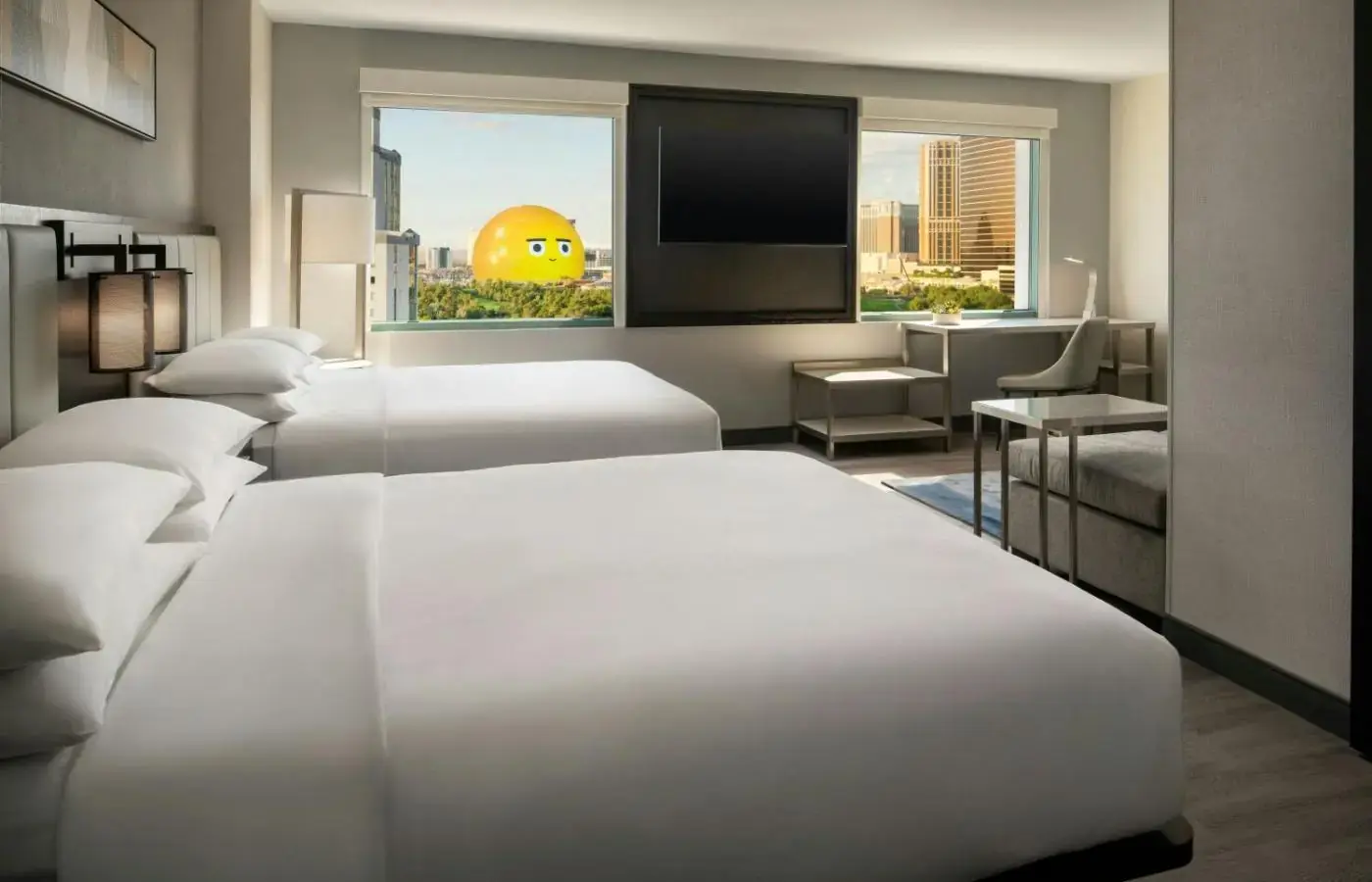 a hotel room with three beds and a flat screen tv at Las Vegas Marriott in Las Vegas