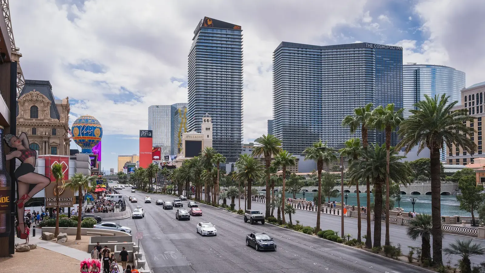 People walking on the Las Vegas Strip sidewalk with The Cosmopolitan towers ahead