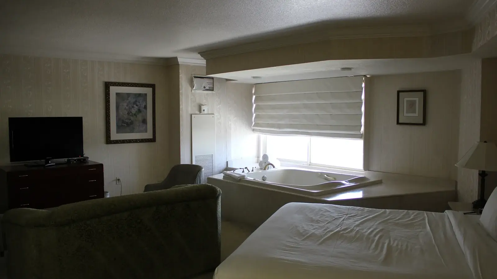Las Vegas hotel suite with a jetted spa tub by the window next to the bed