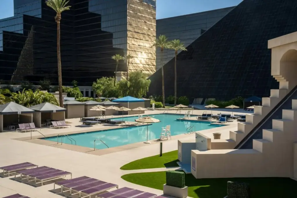 a pool with chairs and umbrellas next to a building at Luxor in Las Vegas