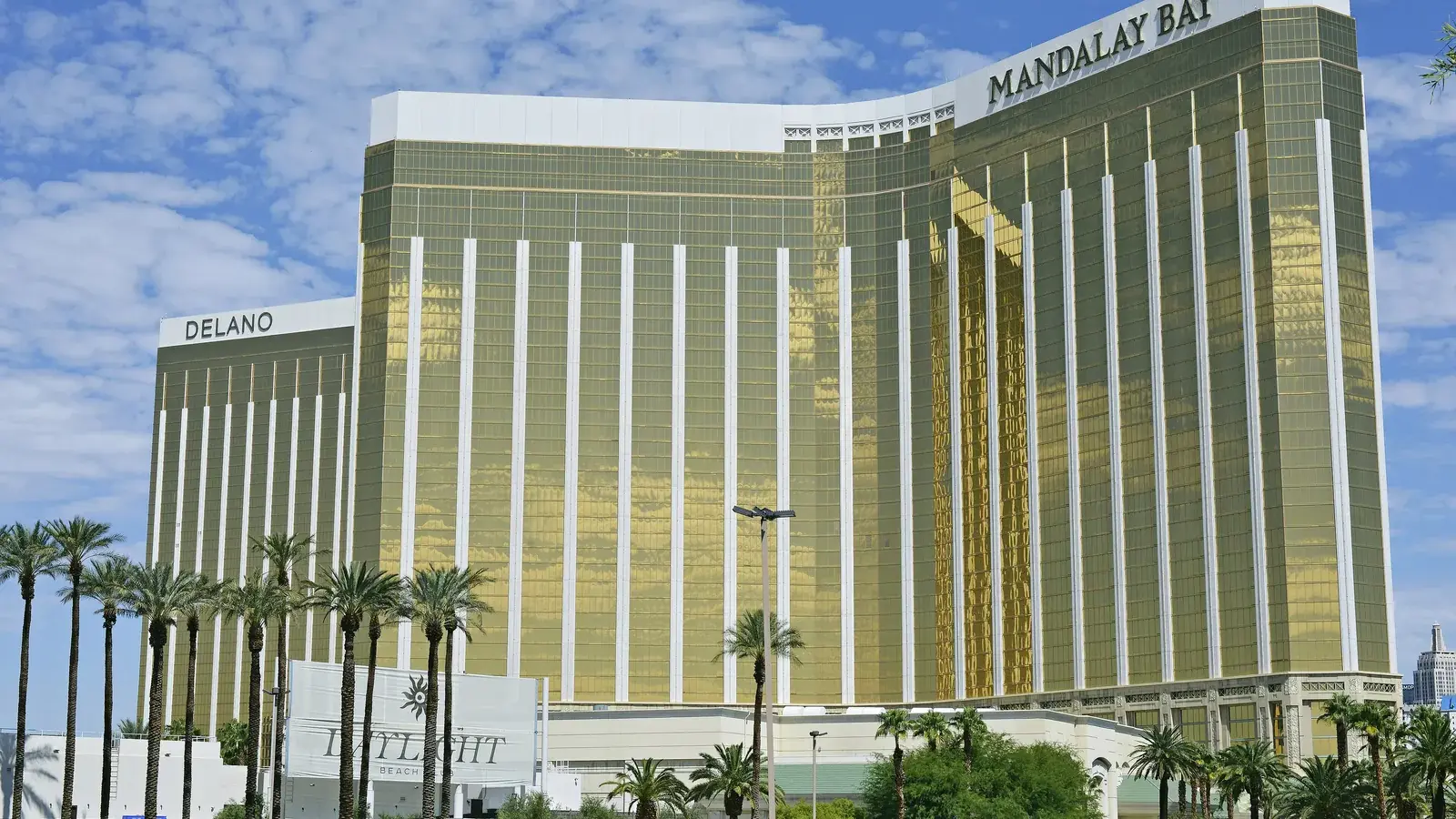 Mandalay Bay's gold glass hotel tower with palm trees