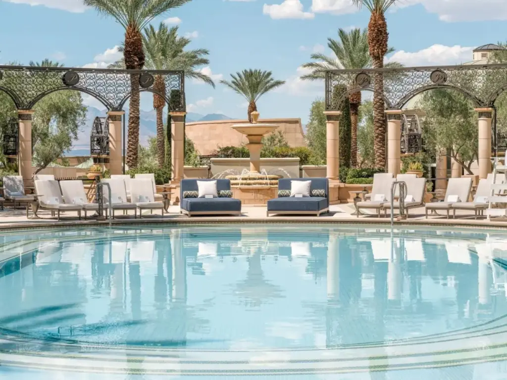 a swimming pool with chairs and a fountain at The Palazzo at The Venetian® in Las Vegas