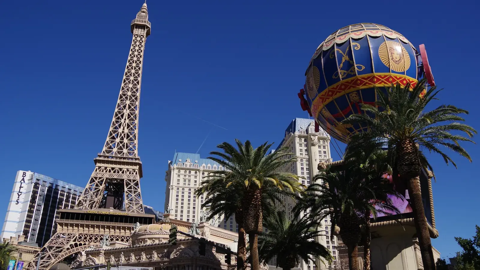 Paris Las Vegas Eiffel Tower replica and balloon sign under a blue sky