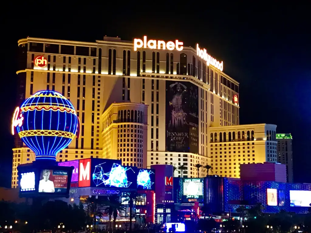 Planet Hollywood Resort & Casino lit up at night with the Paris balloon sign