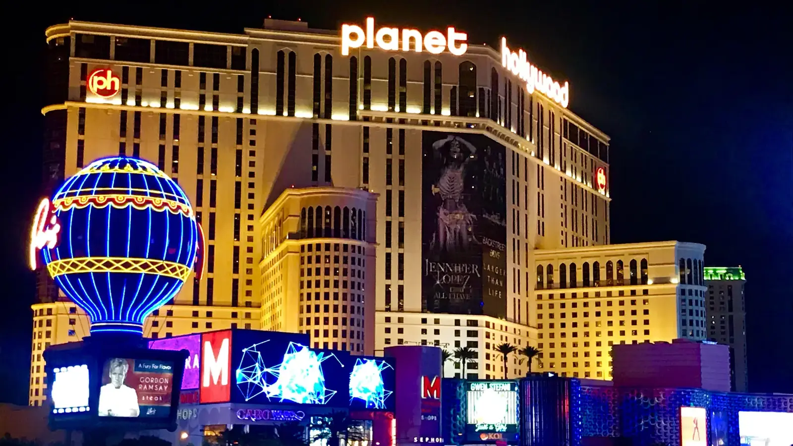 Planet Hollywood Resort & Casino lit up at night with the Paris balloon sign