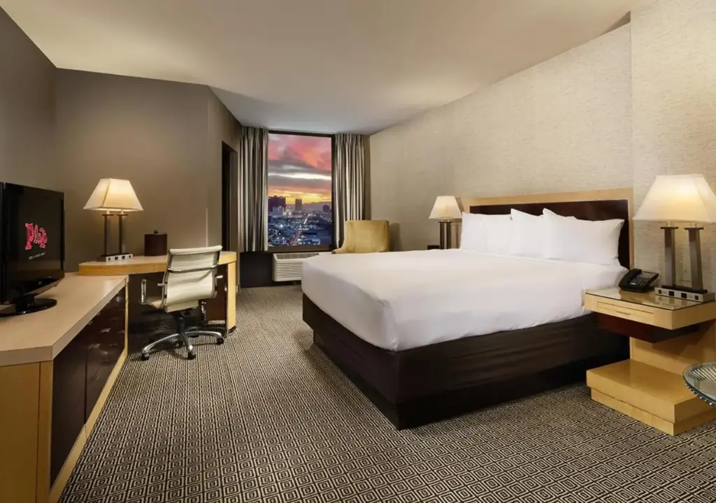 a hotel room with a bed and a desk with a computer at Plaza Hotel & Casino in Las Vegas