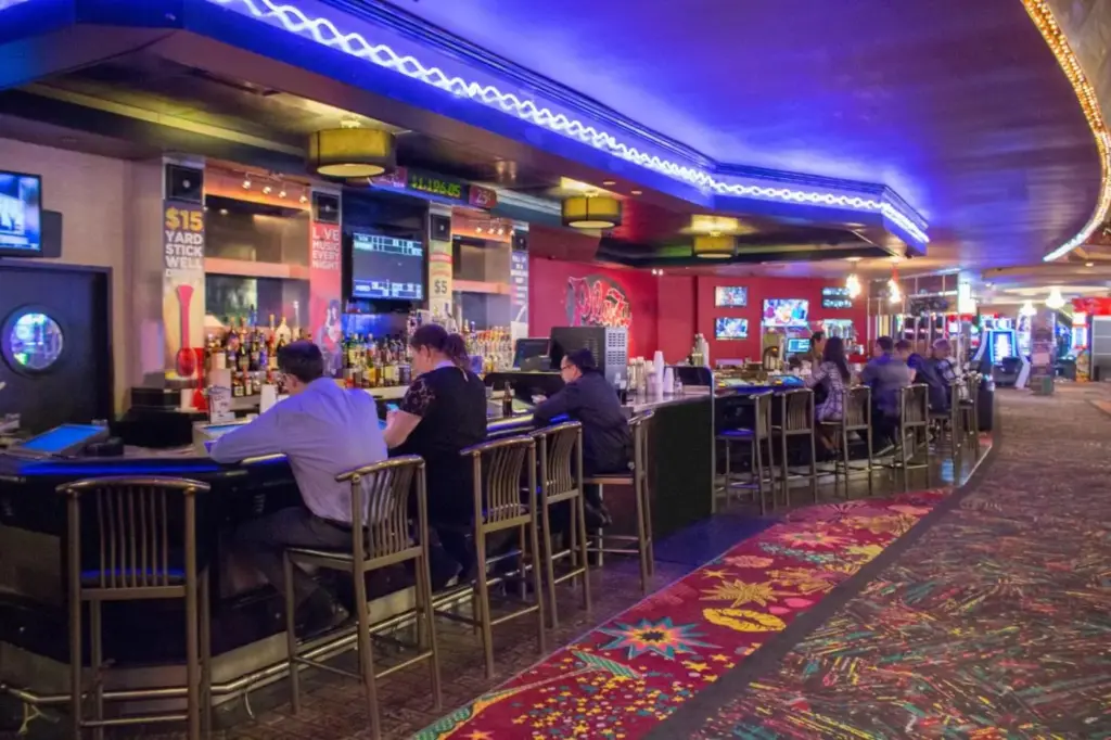 a group of people sitting at a bar in a casino at Plaza Hotel & Casino in Las Vegas