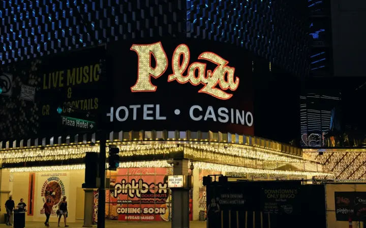 Plaza Hotel & Casino sign lit up at the end of Fremont Street