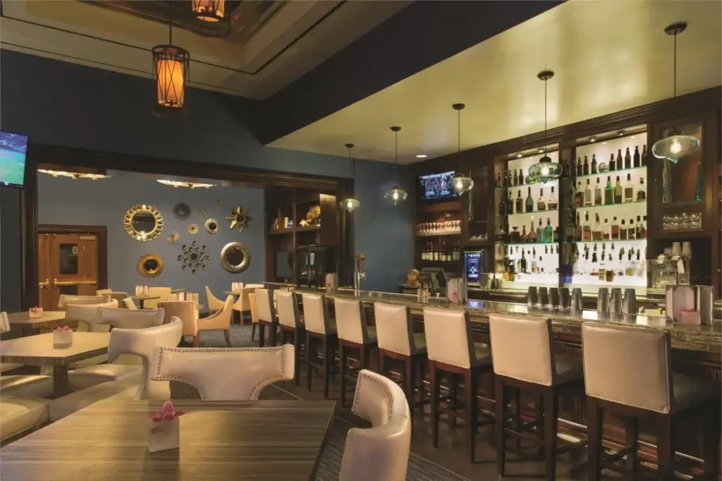 a restaurant with white chairs and a bar at The Signature at MGM Grand - All Suites in Las Vegas
