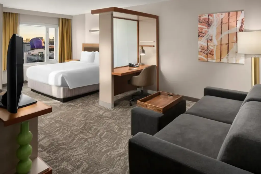 a hotel room with a bed and a couch at SpringHill Suites by Marriott Las Vegas Convention Center in Las Vegas